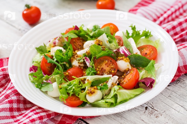 Dietary salad with tomatoes, mozzarella lettuce with honey-mustard dressing, stock photo