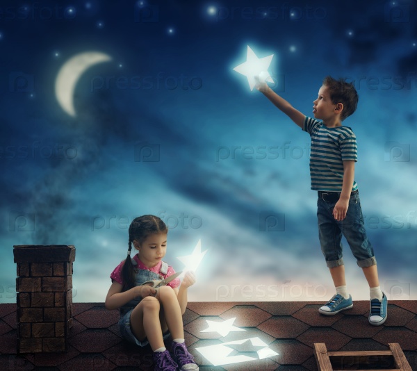 Fairy tale! The children hung the stars in the sky. Boy and girl on the roof cut out stars.