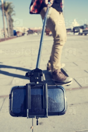 Stock Photo: skater taking a self-portrait with a selfie stick