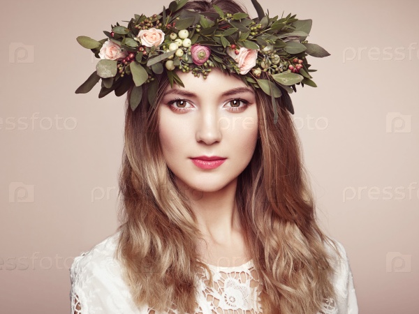 Beautiful blonde woman with flower wreath on her head. Beauty girl with flowers hairstyle. Perfect makeup. Beauty fashion. Spring woman, stock photo