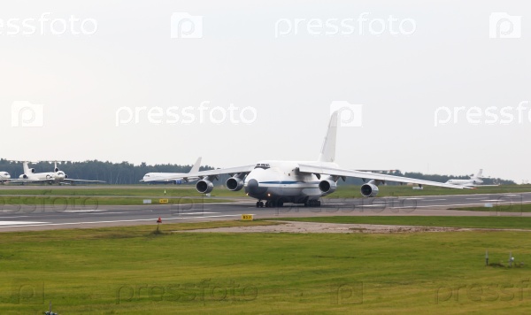 White heavy cargo jet with four engines take off in the airport