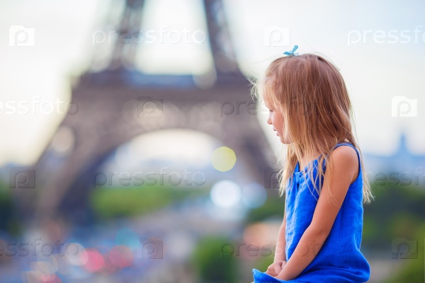 Adorable little girl in Paris background the Eiffel tower during summer vacation, stock photo