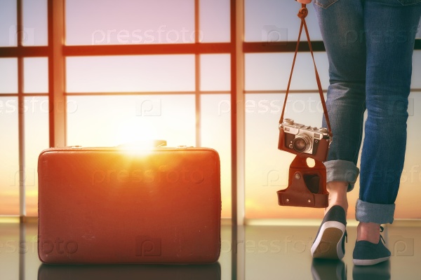 Young woman looks out the window at the airport, stock photo