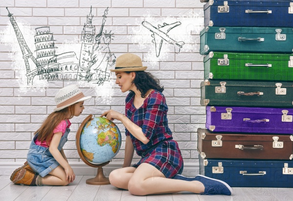 happy family preparing for the journey. mother and daughter looking at a globe and choose a country to travel.