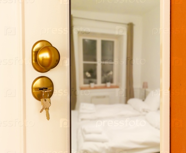 Open door to bedroom with white beds, stock photo