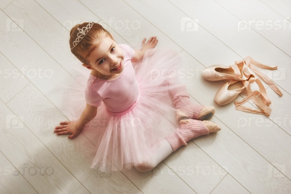 Cute little girl dreams of becoming a ballerina. Child girl in a pink tutu dancing in a room. Baby girl is studying ballet, stock photo