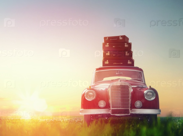 Toward adventure! The suitcases are on the roof of a vintage car, stock photo