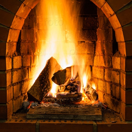 Open fire in fire-box of brick fireplace in country cottage, stock photo