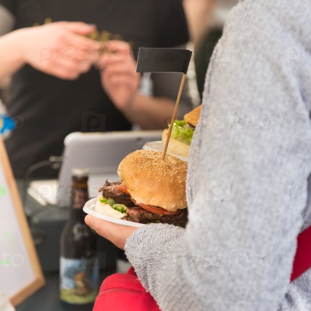 Beef burgers being served on food stall on open kitchen international food festival event of street food, stock photo