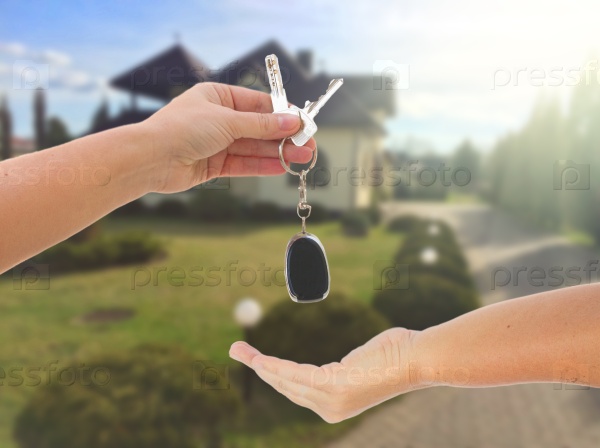 Handling a keys, two hands and residential area background, stock photo