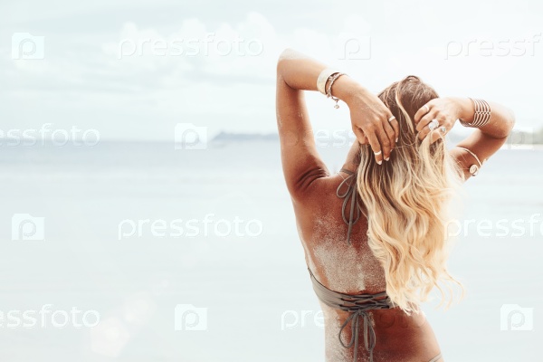 Beautiful bohemian styled and tanned girl at the beach in sunlight, stock photo
