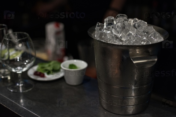 Ice bucket filled with ice cubes closeup, stock photo