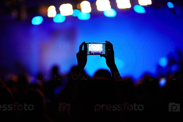 One of fans making video of live concert of modern singer, stock photo