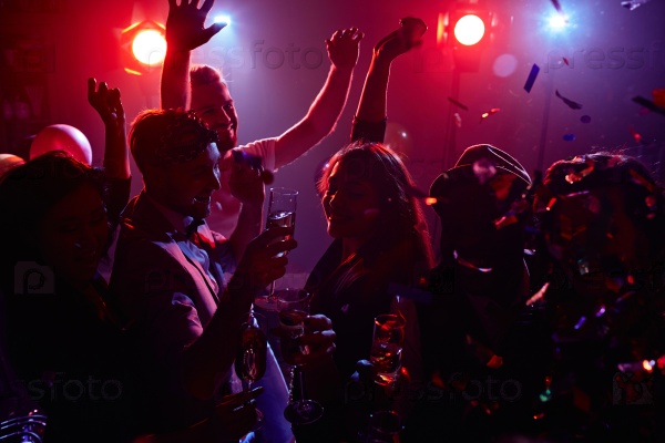 Joyful friends with champagne dancing in disco club, stock photo
