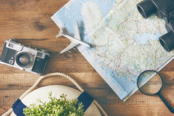 Go on an adventure! The map and the camera on a wooden table. Top view, stock photo