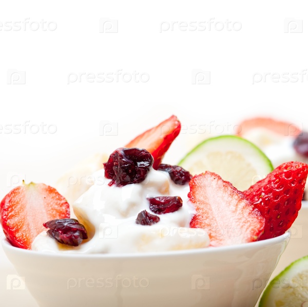 Fruit and yogurt salad healthy breakfast over white wood table, stock photo