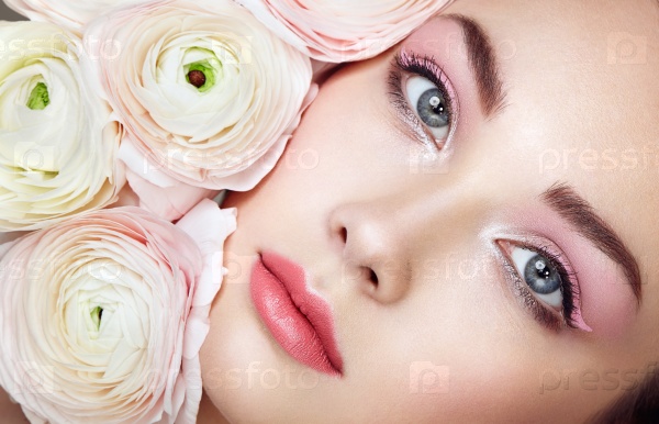 Portrait of beautiful young woman with flowers. Brunette woman with luxury makeup. Perfect skin. Eyelashes. Cosmetic eyeshadow, stock photo
