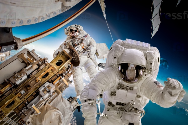 International Space Station and astronaut in outer space over the planet Earth. Elements of this image furnished by NASA, stock photo