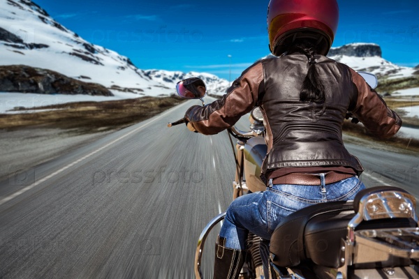 Biker girl rides a motorcycle in the rain. First-person view, stock photo