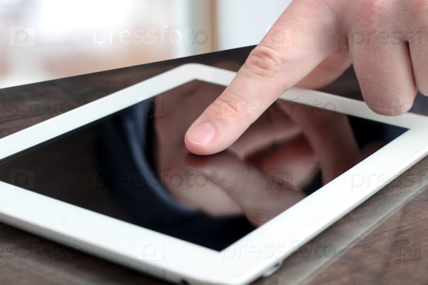 male hand touching tablet with finger tip