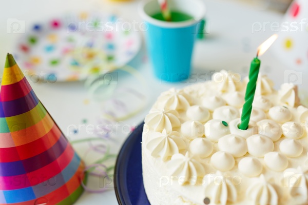 Birthday cake with candle on festive table, stock photo