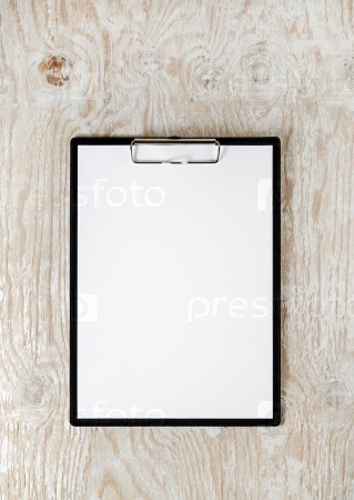 Photo of clipboard with a blank sheet of paper on light wooden background with plenty of copy space. Blank template for design presentations and portfolios. Mock-up for branding identity.