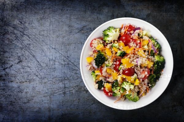Quinoa salad with broccoli,bell peppers, carrot, onion and tomatoes on a rustic metal background. Superfoods concept, stock photo