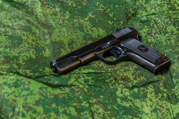 Weathered generic russian soviet semi-automatic 9mm pistol on pixel camouflage background, stock photo