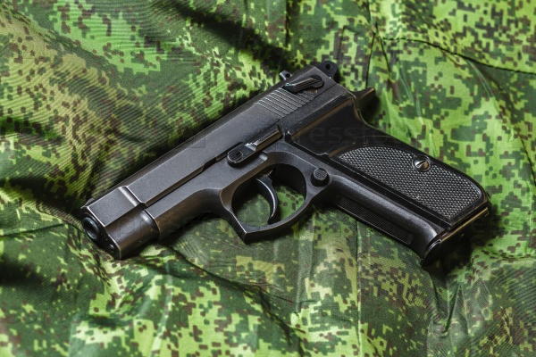 Weathered generic russian soviet semi-automatic 9mm pistol on pixel camouflage background, stock photo