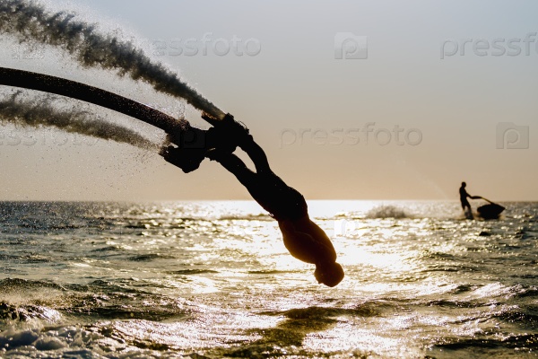 Silhouette of a fly board rider at sea, stock photo