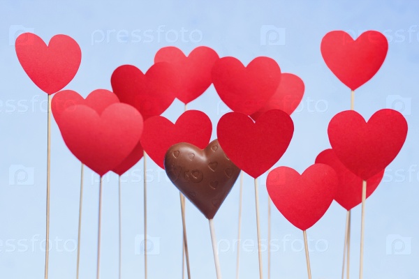 Valentine\'s day hearts on a stick with chocolate heart isolated on light blue background