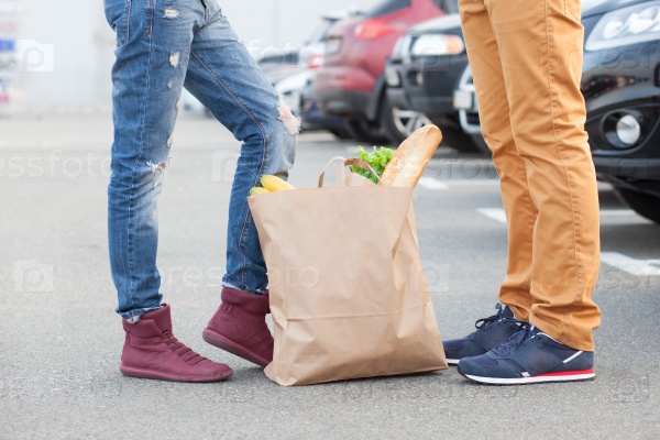 Couples foot and shopping bag with food