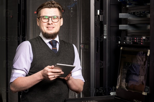 Young engineer wearing glasses in a datacenter, stock photo