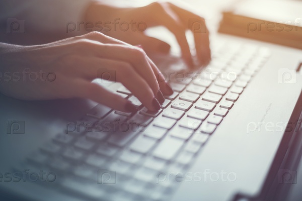 Woman working in home office hand on keyboard close up.