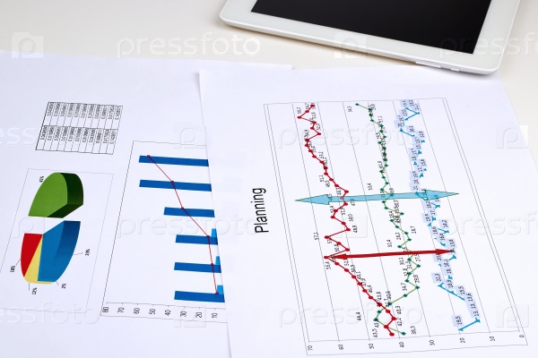 Business graph analysis report. Digital tablet beside