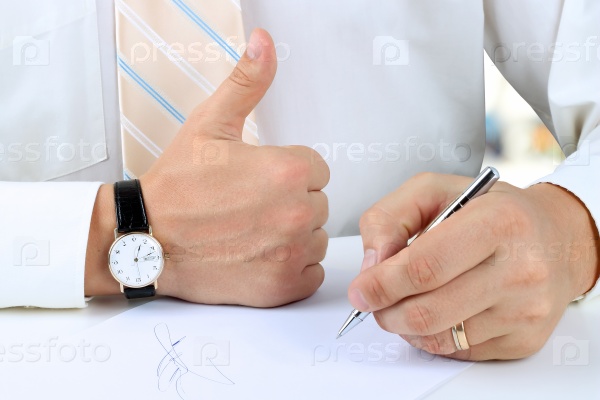 Businessman  signing a document  by pen and showing OK sign with his thumb up.