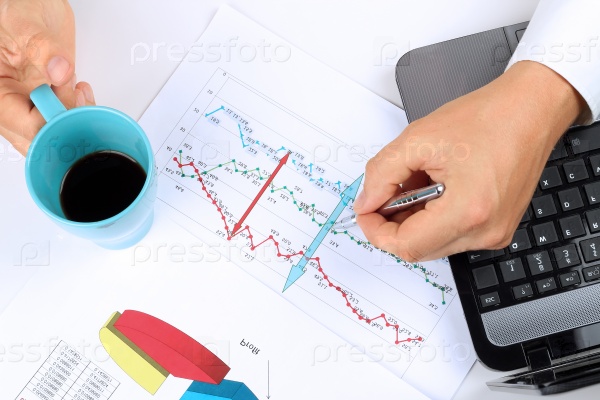 young businessman working in the office,  sitting at his desk, analyzing  data in  graphics