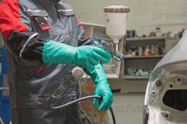 Spray gun with paint for painting a car , stock photo