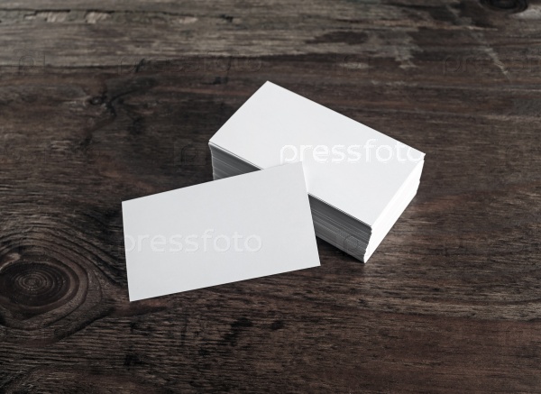 Blank white business cards on dark wooden background. Mock-up for branding identity. Blank template for design presentations and portfolios.