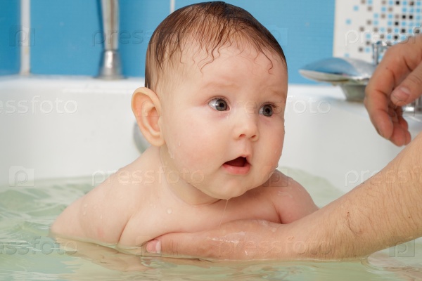 Newborn baby bathe and swim in a large tub, stock photo