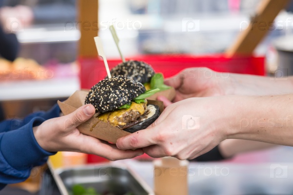 Beef burgers being served on food stall on open kitchen international food festival event of street food, stock photo