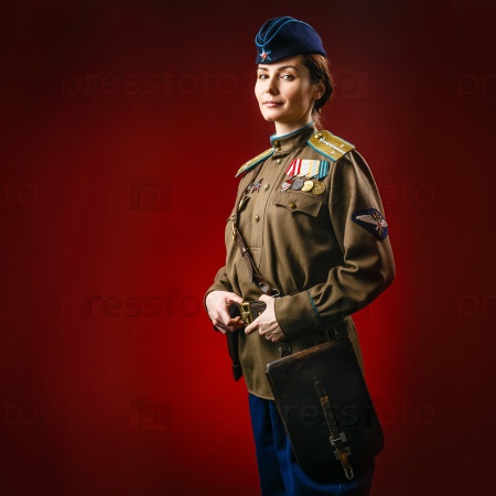 Historical reenactment of soviet union army by pretty woman in beautiful light on red background, stock photo