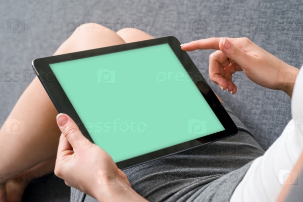 Woman takes a rest with tablet, on sofa. Clipping path included.