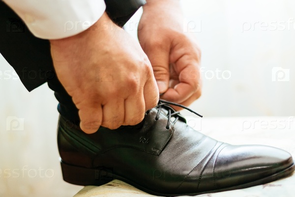 Groom tying shoe laces groom hand shoes, stock photo
