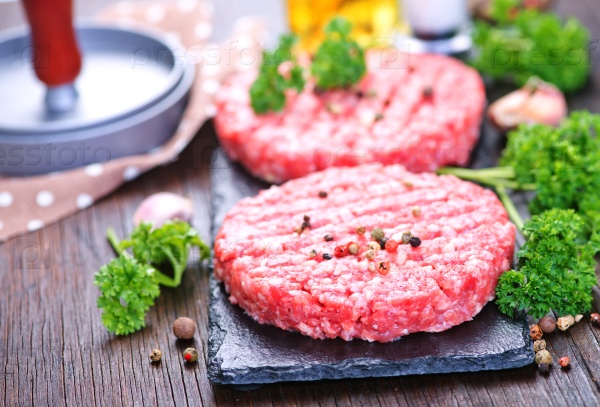 Raw burgers on board with salt and spice, stock photo