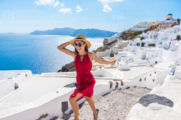 Travel Tourist Happy Woman Running Stairs Santorini, Greek Islands, Greece, Europe. Girl on summer vacation visiting famous tourist destination having fun smiling in Oia.