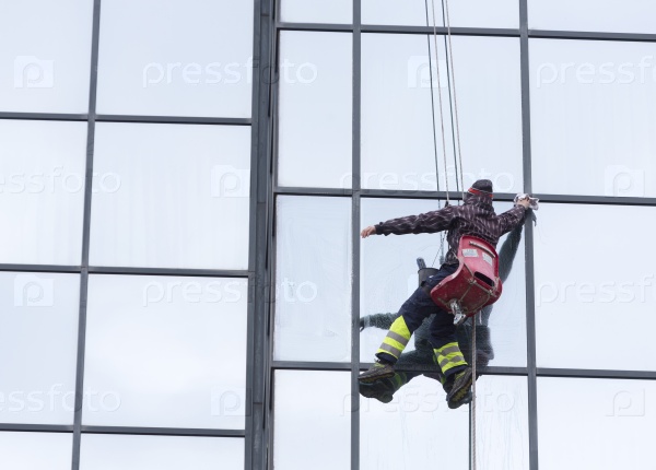 Sofia, Bulgaria - April 7, 2015: Sanitation worker are cleaning the glass facade of a hotel in the center of Sofia.
