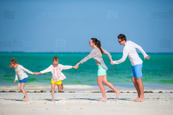 Happy beautiful family on white beach having fun, stock photo