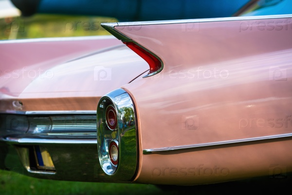 Close-up of the rear of the pink vintage car. Back view of retro car. Vintage pink car. Detail of a vintage car. Selective focus, stock photo