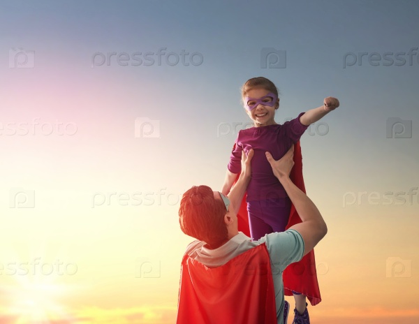 Happy loving family. Father and his daughter child girl playing outdoors. Daddy and her child girl in an Superhero\'s costumes. Concept of Father\'s day.
